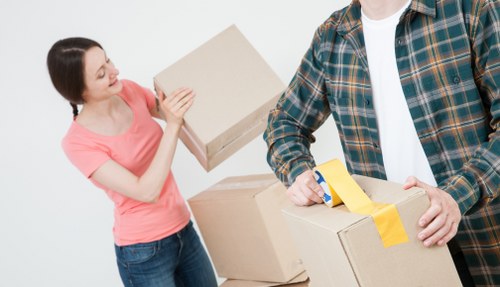 Professional movers transporting large furniture through a Hendon property